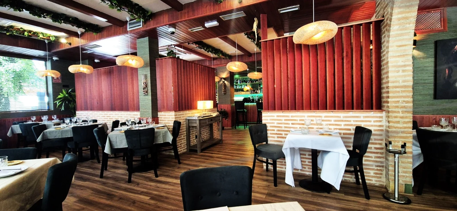 Interior de Restaurante Manila con madera, ladrillo, vegetación y luz cálida